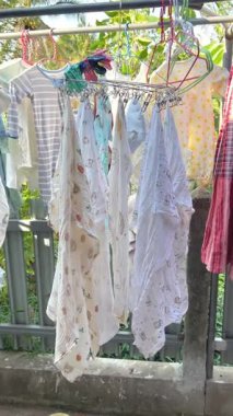 Bebek elbiselerini güneş ışığı altında kurutmak Bebek Çamaşırlarını yıkadıktan sonra