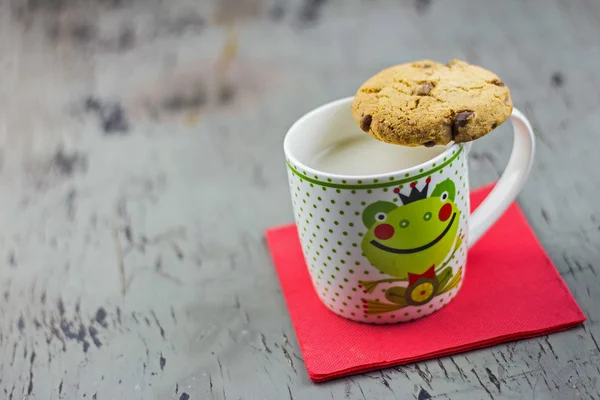 Breakfast background, Tasty cookie on mug of milk — Stock Photo, Image