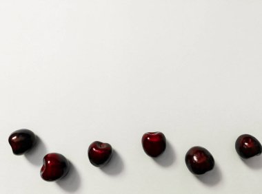 Beyaz arka planda bir yılanla kaplanmış kiraz.