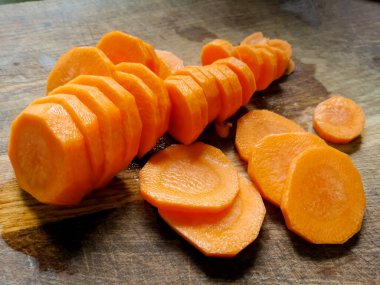 Tahta bir tahtanın üzerinde turuncu havuçlar kesilmiş halkalar.