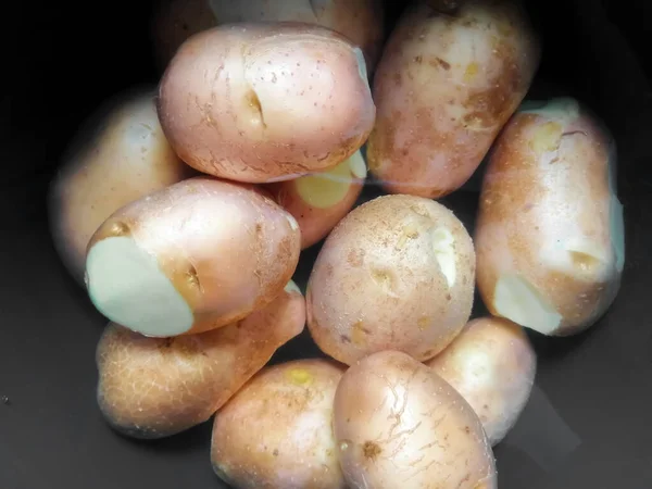 Batatas lavadas, inteiras em uma panela preta — Fotografia de Stock