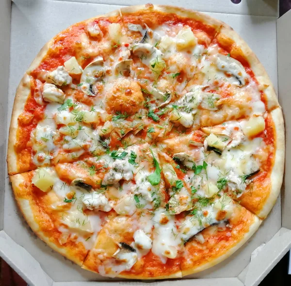 Taze, yuvarlak bir pizza karton bir kutuda.