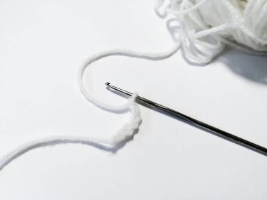 Beyaz arkaplanda, beyaz iplikler örgü örgüsüyle bağlanır.