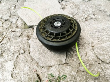 Kesici için yeşil çizgileri olan bir makara betonun üzerinde yatıyor.