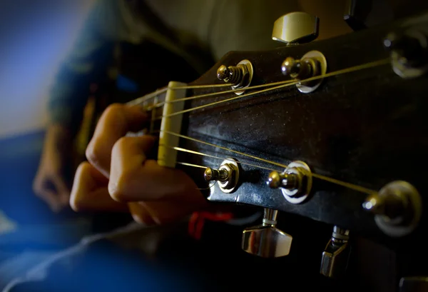 Guitarra nas mãos em uma luz azul Imagem De Stock