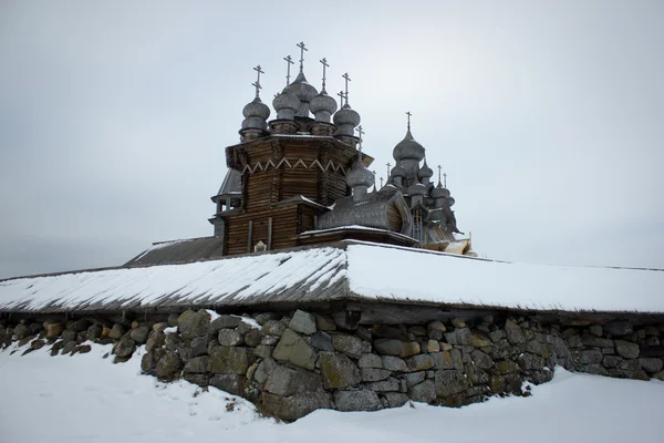 Vecchia cattedrale in legno con recinzione in pietra in inverno — Foto Stock