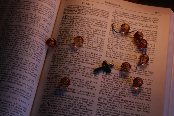 Torn rosary on an open Bible — Stock Photo, Image