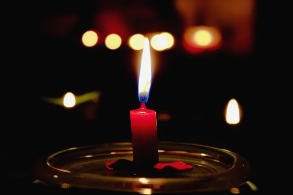 Red candle burning in the dark — Stock Photo, Image