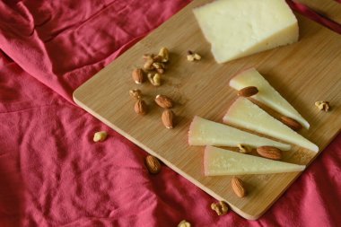 Kırmızı kumaşın üstünde fındıklı manchego peyniriyle fotokopi alanımız var.