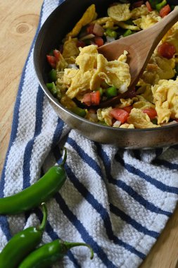 Tavada Meksika yumurtalarının dikey yakın çekimi, çizgili bulaşık bezi, ahşap masa.