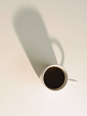 Üzerinde koyu gölgeli kahve, açık arkaplan ve boşluğu kopyalayan beyaz fincan resmi.