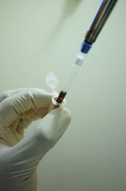 Pipet ve tüple çalışan bilim adamlarının yakın çekimi.