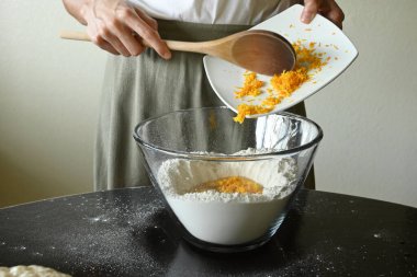 Mangır karışımına portakal döken genç bir kadın.