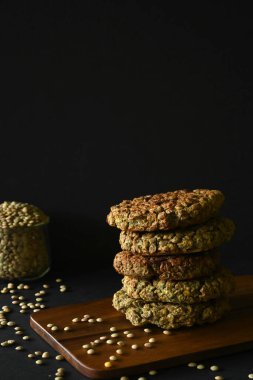 Tahtadaki mercimek köfteleri yığını, siyah arkaplan ve kopyalama alanı.