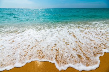 Temiz kumsalda yumuşak mavi okyanus dalgası