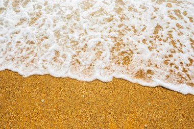 Temiz kumsalda yumuşak mavi okyanus dalgası