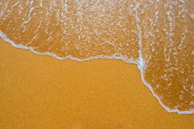 Temiz kumsalda yumuşak mavi okyanus dalgası