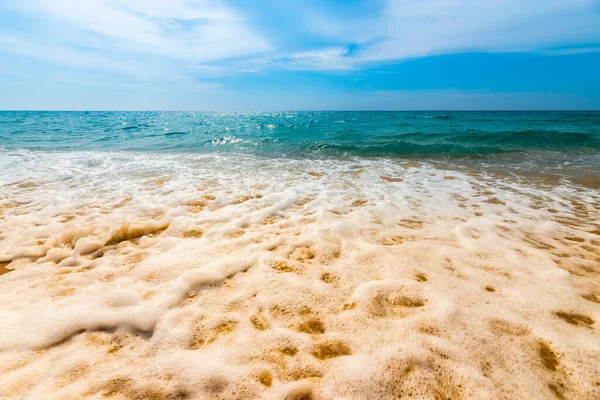 Soft blue ocean wave on clean sandy beach