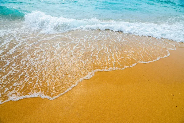 Soft blue ocean wave on clean sandy beach