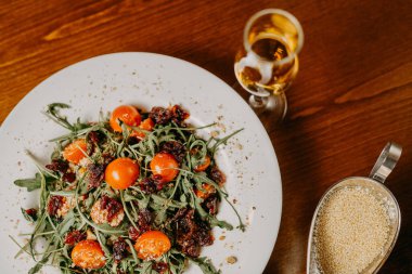 Salatalık, domates, roka ve susam soslu taze salata.