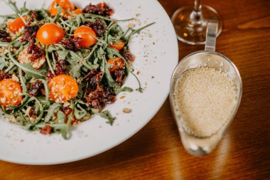 Salatalık, domates, roka ve susam soslu taze salata.