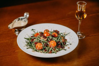 Salatalık, domates, roka ve susam soslu taze salata.