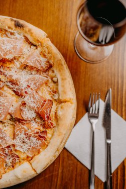 Lezzetli pizza ve pişirme malzemeleri siyah beton arka planda domates fesleğeni. Sıcak pizzanın en üst görüntüsü