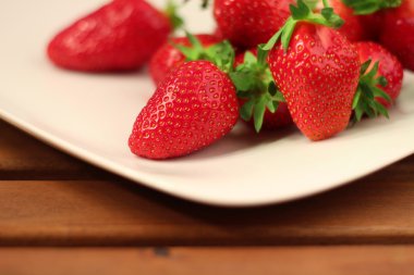 Tahta masadaki taze çilekler.