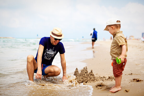 father and son build sand castle