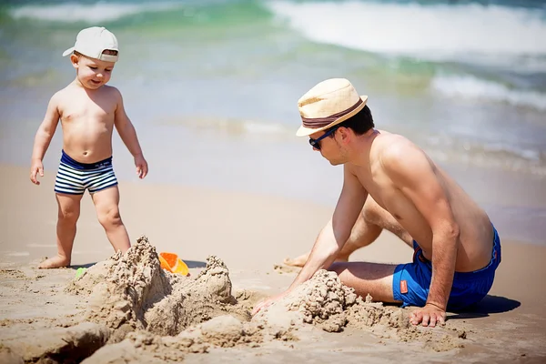 Far och son bygga sandslott — Stockfoto