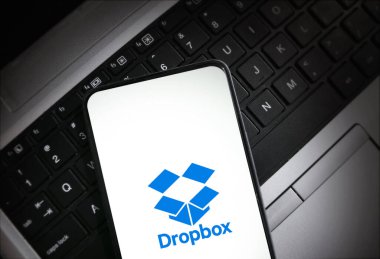 Beyaz akıllı telefon ekranındaki dropbox logosu bir dizüstü bilgisayara yerleştirilmiş, illüstrasyonal arka plan
