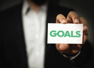 Elinde tipografi olan bir adam tarafından gösterilen hedefler ve hedefler kavramı.