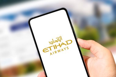Etihad Havayolları logosu akıllı telefon ekranında resimli editör seyahati ve teknoloji konseptinde sergilendi