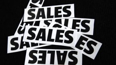 Kağıt parçalarına yazılı satış metinleri. Rastgele siyah arka plan, iş konsepti ile dağılmış..