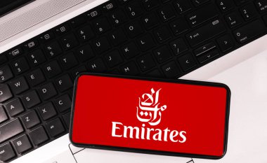 Arkaplanda dizüstü bilgisayarı olan Emirates Havayolları mobil uygulama kavramı. Editoryal havayolu uygulama arkaplanı