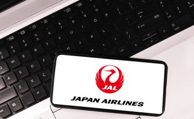 Mobil uygulamalı Japon havayolu şirketi. Arkaplanda dizüstü bilgisayarı var. Editoryal havayolu kavramı