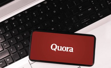Quora 'yı çevrimiçi Q & A platformu konsepti için klavye arkaplan illüstrasyonunda gösteren cep telefonu