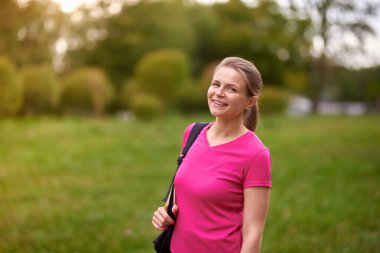 Gülümse genç bayan spor giyimli Park yolunda koşuyor