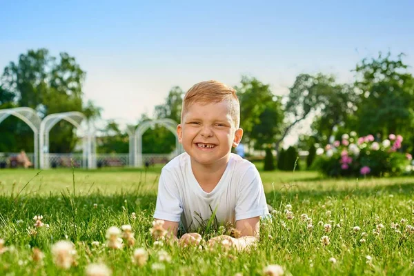 Liten Rödhårig Femårig Pojke Ligger Magen Gräset Parken Och Ler — Stockfoto