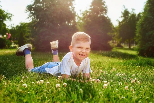 Liten Söt Femårig Rödhårig Pojke Ligger Magen Park Gräset Solljuset — Stockfoto