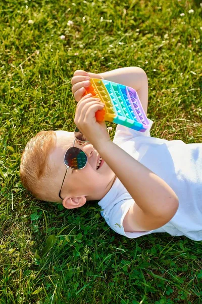 Liten Rödhårig Femårig Pojke Solglasögon Ligger Gräset Ryggen Parken Och — Stockfoto