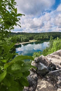 Gölün arka planında taşlar ve odun