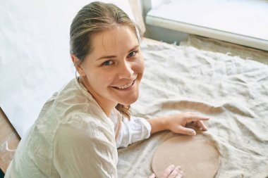 Çamur tabakasının arkasında gülümseyen güzel kız.