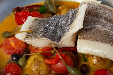 Rezene tohumları ve baharatlı hardal sosuyla süslenmiş, kızarmış vişneli domates salatası ve mor fesleğenle servis edilen kızarmış halibut.