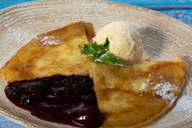 Kremalı böğürtlen soslu ve dondurmalı ince krepler. Yakın plan. Krep Sürünen-Suzette