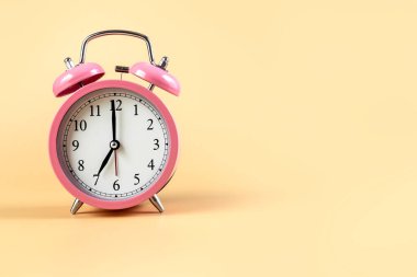 Bej arka planda pembe alarm saati. Zaman kavramı. Mesajın için yer aç. Yüksek kalite fotoğraf