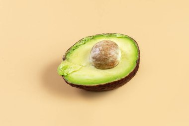 Bej arka planda taze avokado. Kemikli yarım avokado. Sağlıklı beslenme. Kavram.