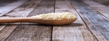 Çiğ pirinç filizleri masaya saçıldı. Tahta bir kaşıkta ve tahta bir tepside pirinç. Sağlıklı beslenme. Diyet yemek. Yakın plan. Yüksek kalite fotoğraf