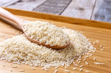 Çiğ pirinç filizleri masaya saçıldı. Tahta bir kaşıkta ve tahta bir tepside pirinç. Sağlıklı beslenme. Diyet yemek. Yakın plan. Yüksek kalite fotoğraf