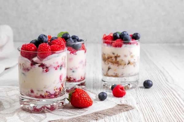 Müsli, yoğurtlu ve böğürtlenli tahta bir masada. Tatlıya hazırlık süreci. Spor yemeği. Boşluğu kopyala.